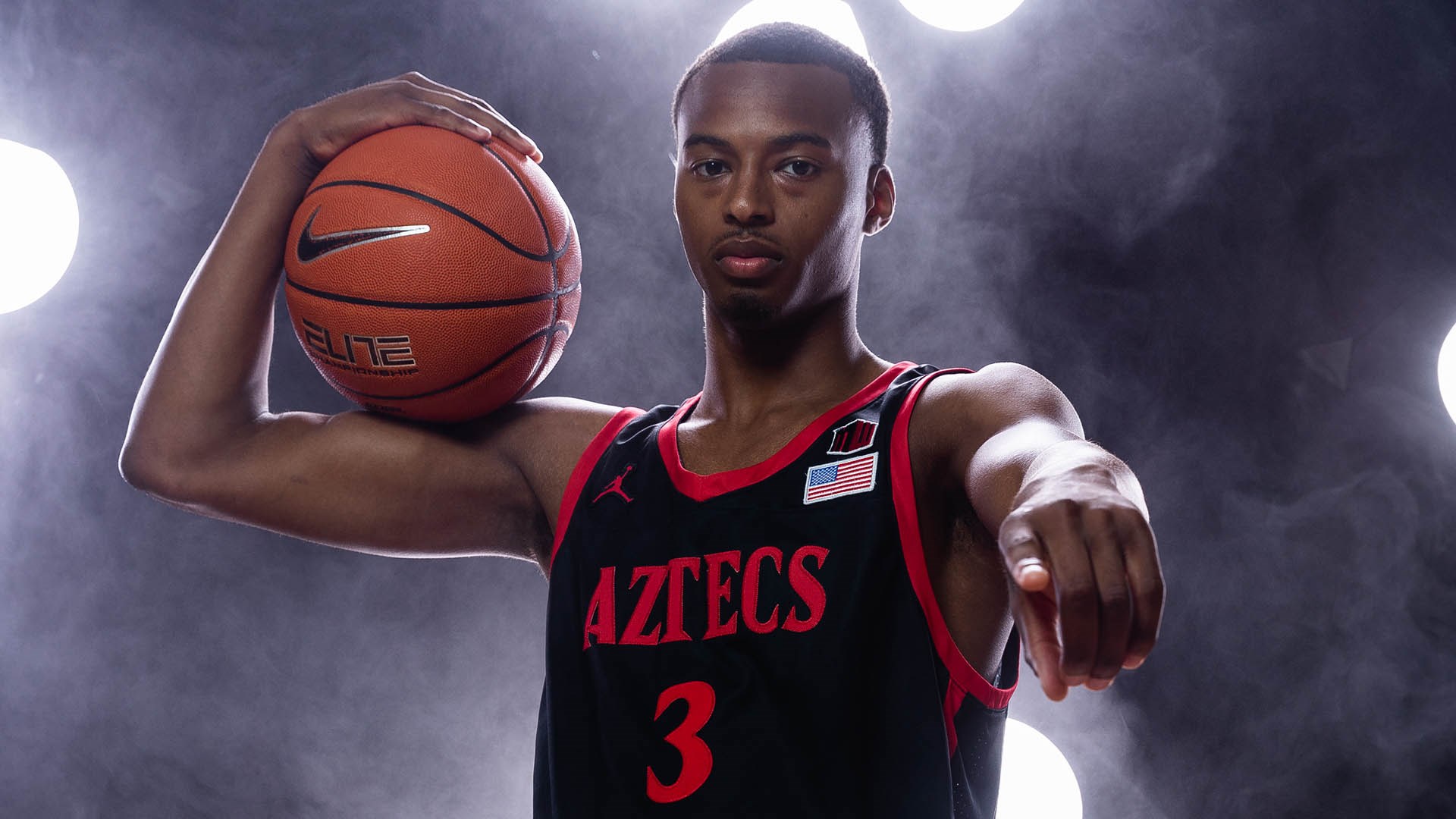 Micah Parrish San Diego State basketball guards holding a basketball.